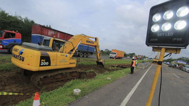 Pekerja mengoperasikan alat berat untuk mengerjakan lajur sementara akibat amblesnya jalan di ruas Tol Cikopo-Palimanan (Cipali) KM 122, Kabupaten Subang, Jawa Barat, Rabu (10/2/2021). [ANTARA FOTO/Dedhez Anggara]