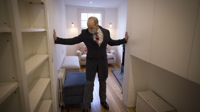 Agen real estate, David Myers memimpin tur ke 'rumah tertipis di London', London Barat, pada (5/2/2021). [Tolga Akmen / AFP]