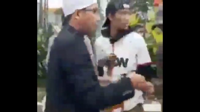 Tangkapan layar video ustadz Maaher saat membagikan uang kepada pengamen. (Twitter/RoyaniDesi)