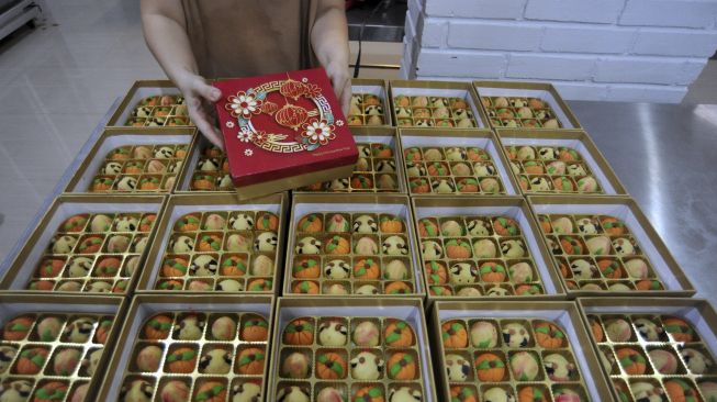 Penjual mengemas kue nastar karakter bertema Imlek di Angie's Cake Denpasar, Bali, Selasa (9/2/2021). [ANTARA FOTO/Fikri Yusuf]