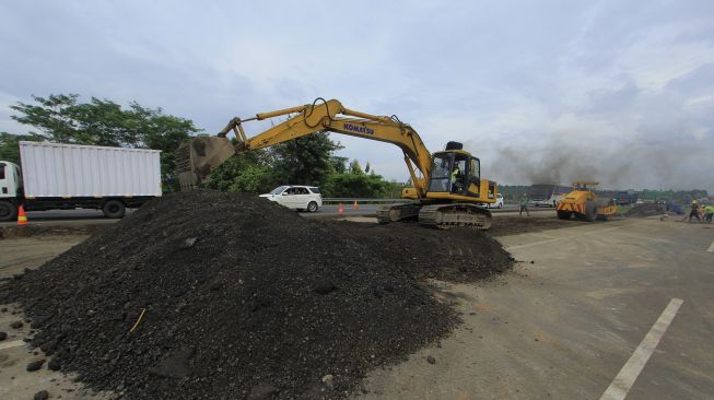 Pekerja mengoperasikan alat berat untuk mengerjakan lajur sementara akibat amblesnya jalan di ruas Tol Cikopo-Palimanan (Cipali) KM 122, Kabupaten Subang, Jawa Barat, Rabu (10/2/2021). [ANTARA FOTO/Dedhez Anggara]