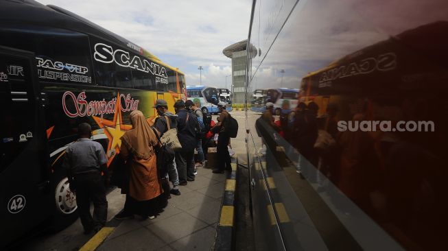 Sejumlah calon penumpang bersiap memasuki bus di Terminal Terpadu Pulo Gebang, Jakarta, Kamis (11/2/2021). [Suara.com/Angga Budhiyanto]