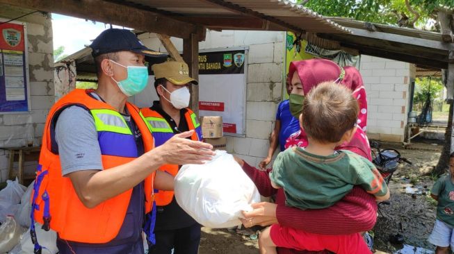 Kepala Dinas Sosial Kabupaten Bekasi Endin Samsudin memberikan bantuan kepada warga terdampak banjir di Desa Panti Bahagia, Kecamatan Muaragembong, Kabupaten Bekasi.(Dok/Pemerintah Desa Pantai Bahagia)