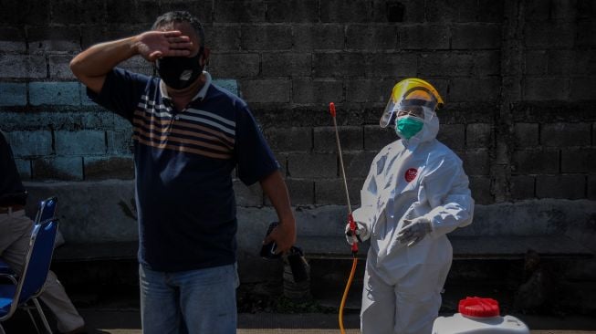 Petugas kesehatan menyemprotkan cairan disinfektan kepada seorang pengendara yang keluar di Gerbang Tol Cileunyi sebelum melakukan tes cepat antigen di Cileunyi, Kabupaten Bandung, Jawa Barat, Kamis (11/2/2021). ANTARA FOTO/Raisan Al Farisi


