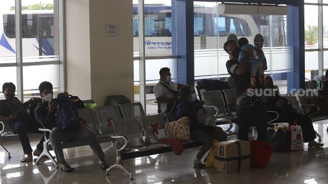 Sejumlah calon penumpang menunggu kedatangan bus di Terminal Terpadu Pulo Gebang, Jakarta, Kamis (11/2/2021). [Suara.com/Angga Budhiyanto]