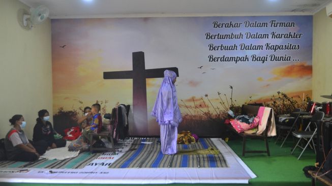 Pengungsi korban banjir melakukan shalat di ruang aula Gereja Kristen Muria Indonesia (GKMI) Tanjung Karang, Kudus, Jawa Tengah, Kamis (11/2/2021). [ANTARA FOTO/Yusuf Nugroho]