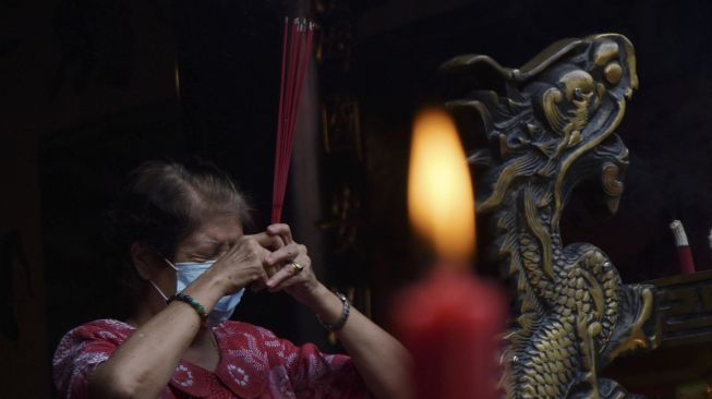 Umat Tri Dharma bersembahyang menyambut Tahun Baru Imlek di Tempat Ibadah Tri Dharma (TITD) Hwie Ing Kiong, Kota Madiun, Jawa Timur, Jumat (12/2/2021). [ANTARA FOTO/Siswowidodo]