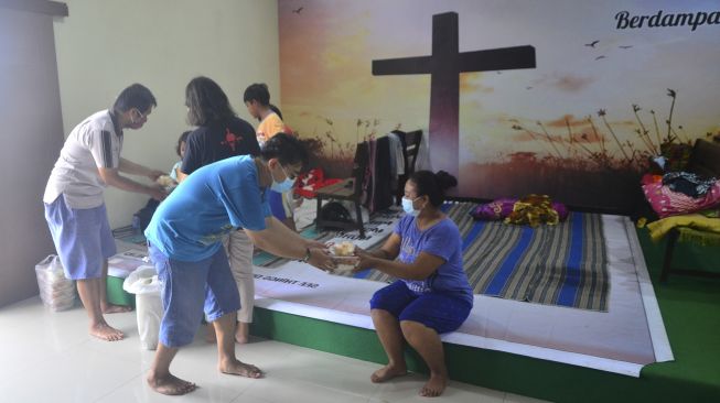 Pengurus gereja membagikan bungkusan nasi di ruang aula Gereja Kristen Muria Indonesia (GKMI) Tanjung Karang, Kudus, Jawa Tengah, Kamis (11/2/2021). [ANTARA FOTO/Yusuf Nugroho]