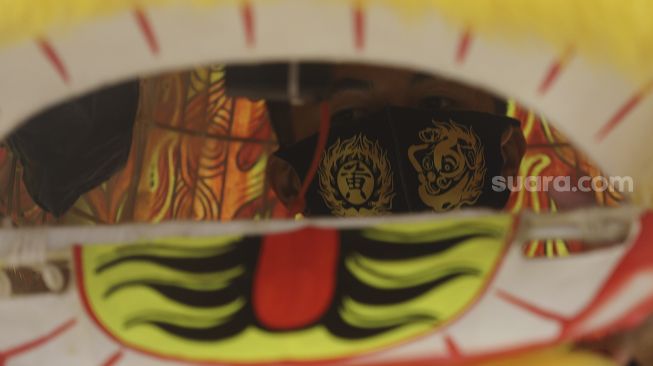 Seorang seniman Barongsai beraksi menghibur pengunjung dalam pertunjukan "Barongsai Spectacles" di Mal Senayan City, Jakarta, Jumat (12/2/2021). [Suara.com/Angga Budhiyanto]