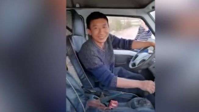 Mr Zhang dari Kunming, Yunnan, Chinese. Tetap ceria dan menciptakan viral seberangkan minivan [Daily Mail/News Dog Media].