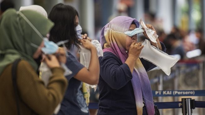 Calon penumpang kereta api mengembuskan nafasnya ke dalam kantong untuk dites COVID-19 dengan GeNose C19 di Stasiun Pasar Senen, Jakarta, Jumat (12/2/2021). [ANTARA FOTO/Aprillio Akbar]