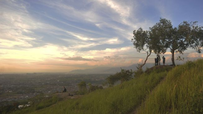 Sejumlah pengunjung menikmati panorama kota dari Bukit Nobita di Kampung Jua, Padang, Sumatera Barat, Jumat (12/2/2021). [ANTARA FOTO/Iggoy el Fitra]