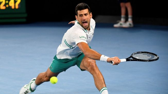 Petenis Serbia, Novak Djokovic lolos ke perempat final Australian Open setelah menundukkan Milos Raonic (Kanada) dalam laga lima set di Rod Laver Arena, Minggu (14/2/2021) malam WIB. [William WEST / AFP]]