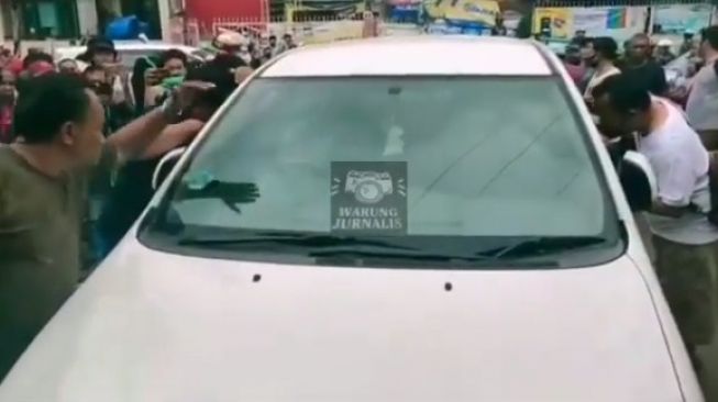 Tangkapan layar petugas polisi mengepung pengemudi mobil Innova yang mengacungkan pistol mainan ke warga di Kedoya, Jakarta Barat, Minggu (14/2/2021). [Instagram]