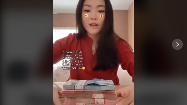 Seorang wanita menghitung isi angpao (TikTok/@junifeng)