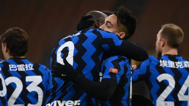 Pemain depan Inter Milan Romelu Lukaku dan pemain depan Inter Milan Lautaro Martinez berpelukan setelah Lukaku membuka skor selama pertandingan sepak bola Serie A Italia Inter Milan melawan Lazio di Stadion Guiseppe Meazza, Senin (15/2/2021) dini hari WIB. Marco BERTORELLO / AFP
