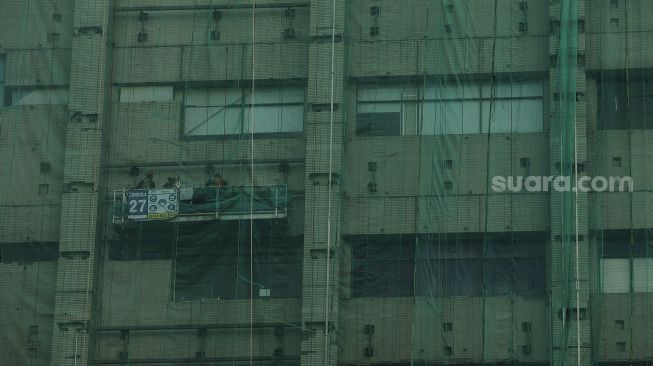 Pekerja menyelesaikan renovasi bangunan Gedung Sarinah di Jalan MH Thamrin, Jakarta, Selasa (16/2/2021). [Suara.com/Angga Budhiyanto]