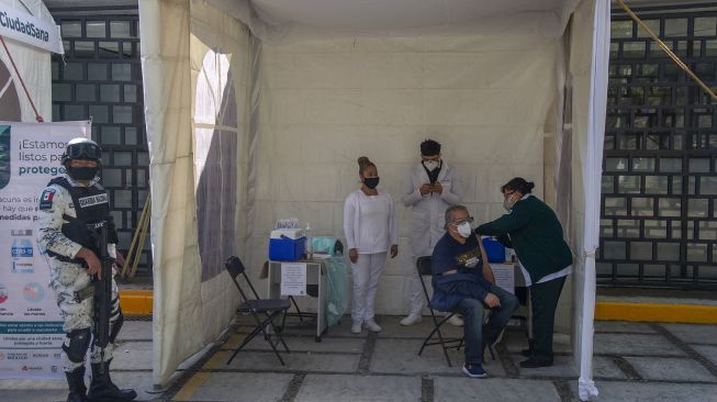 Seorang Pria Lansia menerima dosis pertama vaksin AstraZeneca untuk melawan COVID-19 di Mexico City, pada 15 Februari 2021. Claudio CRUZ / AFP