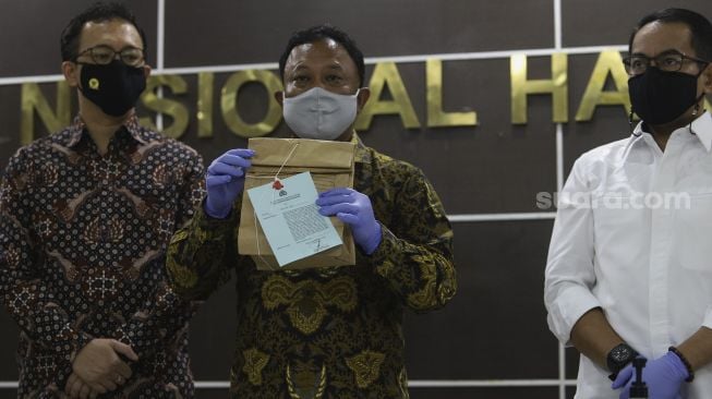 Komisioner Komnas HAM Choirul Anam (tengah) menunjukkan barang bukti terkait tewasnya enam laskar FPI yang masih tersegel sebelum menyerahkan kepada Bareskrim Polri di Kantor Komnas HAM, Jakarta, Selasa (16/2/2021). [Suara.com/Angga Budhiyanto]