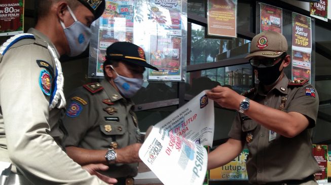 Anggota Satpol PP Kota Bogor melakukan penyegelan tempat wisata air The Jungle Waterpark, Bogor Nirwana Residence (BNR), Kota Bogor, Jawa Barat, Senin (15/2/2021). [ANTARA FOTO/Arif Firmansyah]
