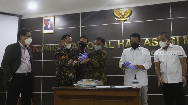 Komisioner Komnas HAM Choirul Anam (ketiga kanan) bersiap menyerahkan barang bukti terkait tewasnya enam laskar FPI kepada Bareskrim Polri di Kantor Komnas HAM, Jakarta, Selasa (16/2/2021). [Suara.com/Angga Budhiyanto]