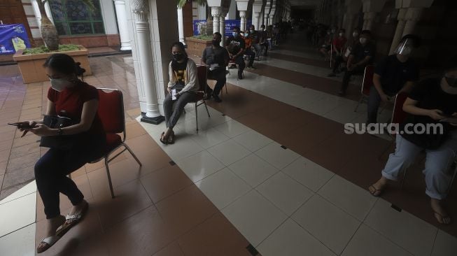 Sejumlah pedagang mengantre untuk mendapatkan vaksin COVID-19 Sinovac di Pasar Tanah Abang Blok A, Jakarta, Rabu (17/2/2021). [Suara.com/Angga Budhiyanto]