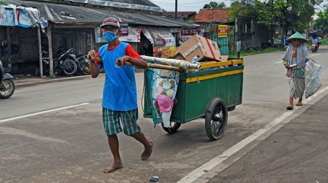 Pemulung melintas di Kampung Ciputri, Kasemen, Serang, Banten, Rabu (17/2/2021). [ANTARA FOTO/Asep Fathulrahman]