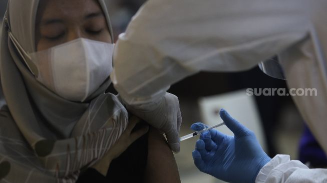 Vaksinator menyuntikkan vaksin COVID-19 Sinovac kepada pedagang di Pasar Tanah Abang Blok A, Jakarta, Rabu (17/2/2021). [Suara.com/Angga Budhiyanto]