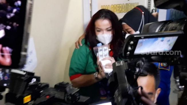 Jennifer Jill Supit alias Jennifer Ipel saat keluar dari Polres Jakarta Barat untuk menjalani pemeriksaan kesehatan, Kamis (18/2/2021). [Evi Ariska/Suara.com]