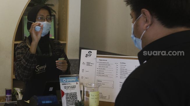 Barista yang seorang tunarungu, dengan menggunakan bahasa isyarat melayani pengunjung di Kafe Sunyi, Cilandak, Jakarta Selatan, Kamis (18/2/2021). [Suara.com/Angga Budhiyanto]