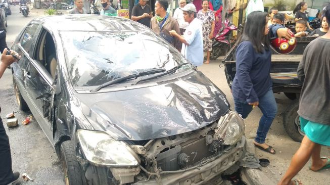 Mobil Sedan Terbalik usai Tabrak Pikap Parkir di Medan. [Ist]