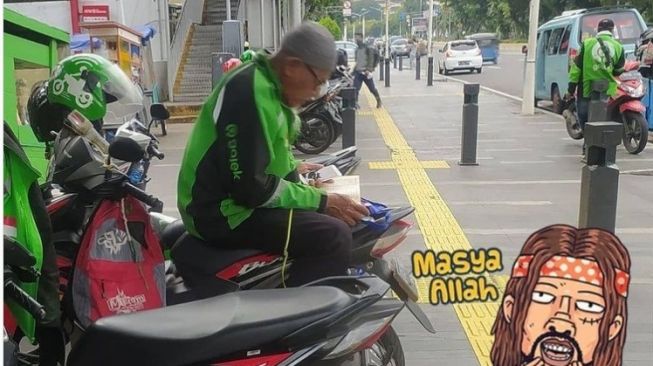 Ojol ini membaca Alquran sambil menunggu orderan penumpang yang masuk (Instagram)