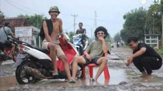 Para pemuda Semuli Raya Lampung Utara pose di jalan rusak [Facebook Andi Irfan Saputra]