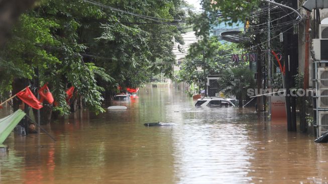 Mobil - mobil terendam banjir di Kemang, Jakarta Selatan, Sabtu (20/2/2021). [Suara.com/Alfian Winanto]