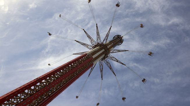 Pengunjung menaiki wahana 'sky flyer' di Taman Bollywood, Dubai, pada (18/2/2021). [GIUSEPPE CACACE / AFP]