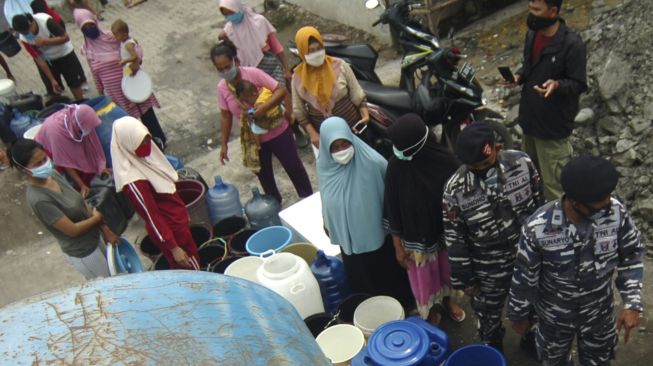 Sejumlah warga antre pembagian air bersih di Kelurahan Muarareja, Tegal, Jawa Tengah, Minggu (21/2/2021). [ANTARA FOTO/Oky Lukmansyah]