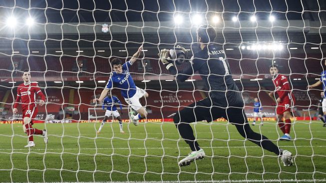 Tendangan ke gawang bek Everton Seamus Coleman diselamatkan oleh penjaga gawang Liverpool Alisson Becker saat pertandingan sepak bola Liga Premier Inggris antara Liverpool dan Everton di Stadion Anfield, Liverpool, Inggris, pada (20/2/2021). [PHIL NOBLE / POOL / AFP]