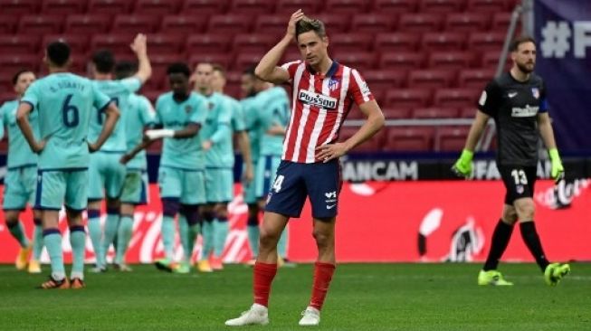 Reaksi pemain Atletico Madrid Marcos Llorente usai timnya dibantai Levante 0-2 di Estadio Wanda Metropolitano di pekan ke-24 La Liga, Sabtu (20/2/2021). [AFP]