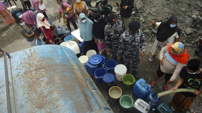 Sejumlah warga antre pembagian air bersih di Kelurahan Muarareja, Tegal, Jawa Tengah, Minggu (21/2/2021). [ANTARA FOTO/Oky Lukmansyah]