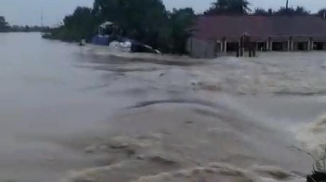 Tangkapan layar tanggul Sungai Citarum di Desa Sumberurip Kabupaten Bekasi jebol. Ratusan warga di Kampung Babakan Banten terendam banjir.[Istimewa]