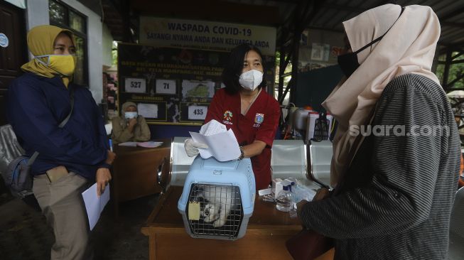 Warga mendaftarkan hewan peliharaannya untuk dilakukan pemeriksaan kesehatan hewan terdampak banjir di Kantor Kelurahan Pela Mampang, Jakarta, Senin (22/2/2021). [Suara.com/Angga Budhiyanto]