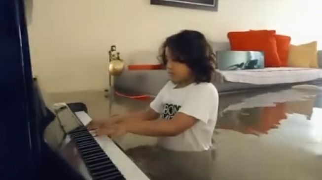 Setengah Badannya Tenggelam, Aksi Anak Main Piano saat Banjir Bikin Terharu