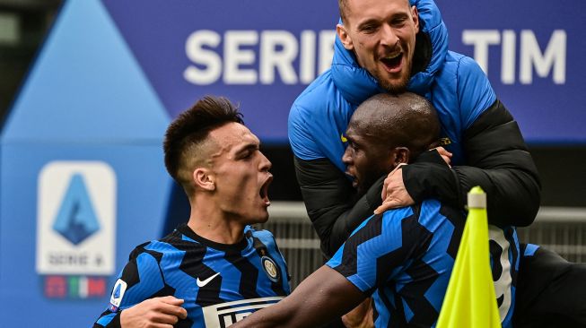 Penyerang Inter Milan Romelu Lukaku (kanan) merayakan golnya  dengan penyerang Inter Milan Lautaro Martinez (kiri) dan Inter Milan Ionut Andrei Radu setelah mencetak gol ketiga selama pertandingan sepak bola Serie A Italia AC Milan melawan Inter Milan di San Siro, Milan, Italia, Minggu (21/2/2021) malam WIB.
MIGUEL MEDINA / AFP
