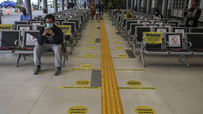 Sejumlah calon penumpang duduk di ruang tunggu Stasiun Pasar Senen di Jakarta, Senin (22/2/2021).  ANTARA FOTO/M Risyal Hidayat