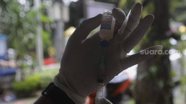 Paramedis dari pusat kesehatan hewan (Puskewan) Dinas Ketahanan Pangan, Kelautan dan Pertanian Kota Administrasi Jakarta Selatan menyiapkan vaksin anti rabies untuk disuntikkan kepada hewan peliharaan terdampak banjir di Kantor Kelurahan Pela Mampang, Jakarta, Senin (22/2/2021). [Suara.com/Angga Budhiyanto]