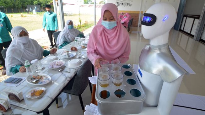 Sebuah robot mengantarkan minuman di Kafe Arfa, Perguruan Diniyah Putri Padangpanjang, Sumatera Barat, Senin (22/2/2021). ANTARA FOTO/Iggoy el Fitra