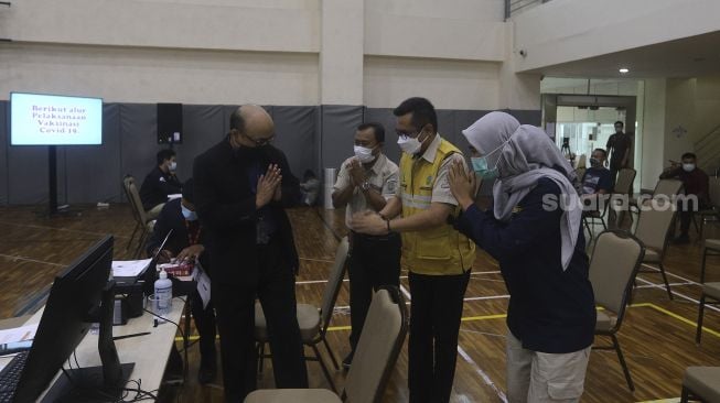 Penyidik senior KPK Novel Baswedan (kiri) menyapa tenaga kesehatan sebelum melakukan vaksinasi COVID-19 di Gedung Penunjang Komisi Pemberantasan Korupsi (KPK), Jakarta, Selasa (23/2/2021). [Suara.com/Angga Budhiyanto]