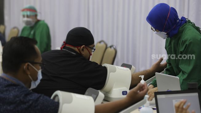 Petugas kesehatan memeriksa kesehatan pegawai KPK sebelum melakukan vaksinasi COVID-19 di Gedung Penunjang Komisi Pemberantasan Korupsi (KPK), Jakarta, Selasa (23/2/2021). [Suara.com/Angga Budhiyanto]