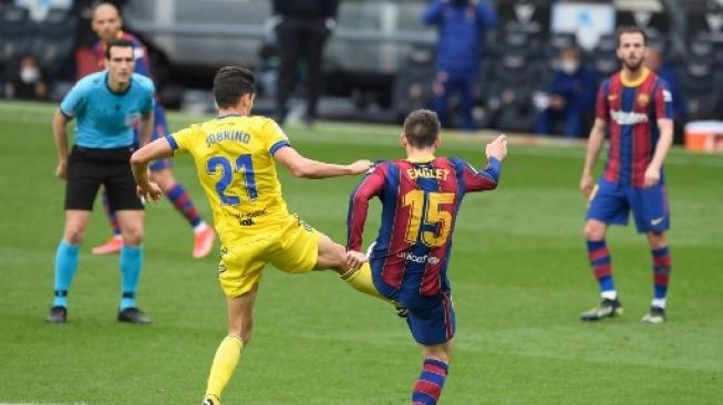 Pemain Barcelona Clement Lenglet berebut bola dengan pemain Cadiz dalam pertandingan Liga Spanyol di Camp Nou, Minggu (21/2/2021). [AFP]