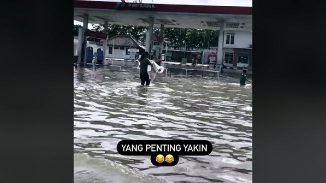 Aksi seorang pria menebar jala di saat banjir (tiktok/@everdedward28)